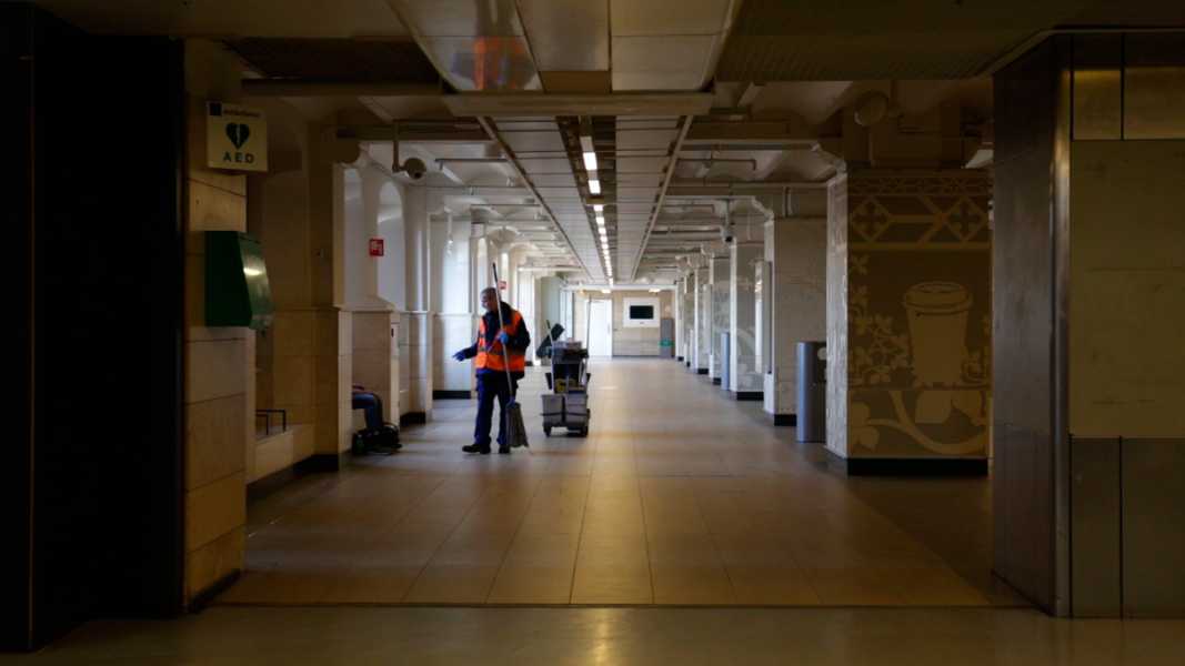 Cleaner at work in a deserted Amsterdam Central Station (still from video Amsterdam, april 2020) foto: Matthijs de Bruijne